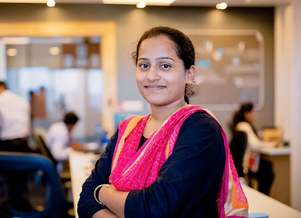 an Indian woman standing and folding her arms